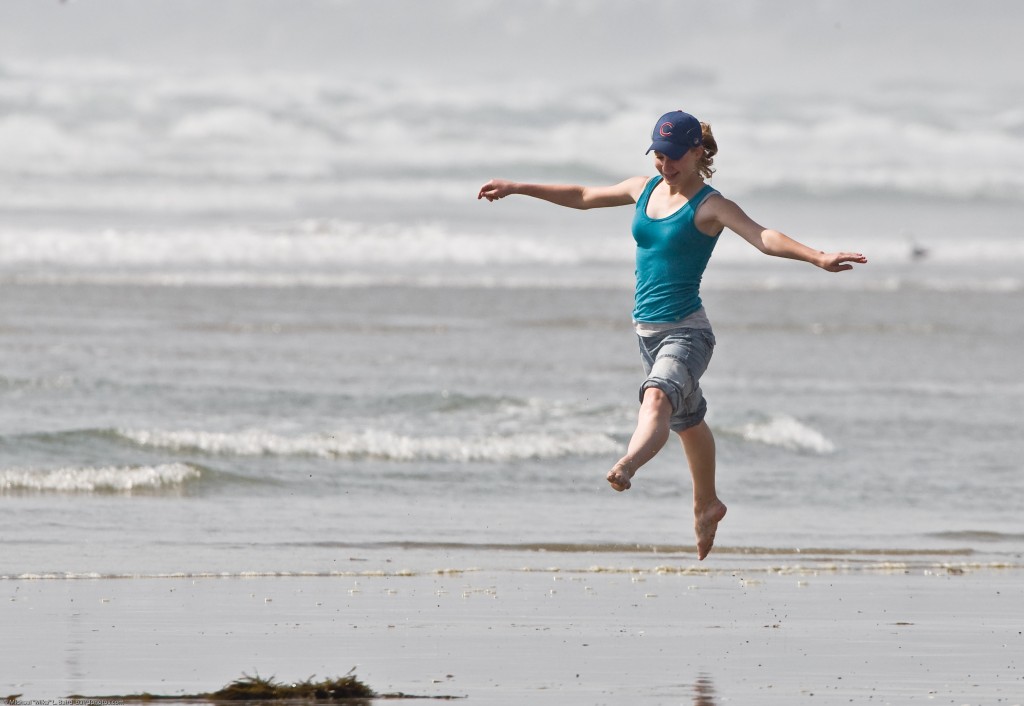 1 of 8 Girl dances at water's edge on Morro Strand State Beach
